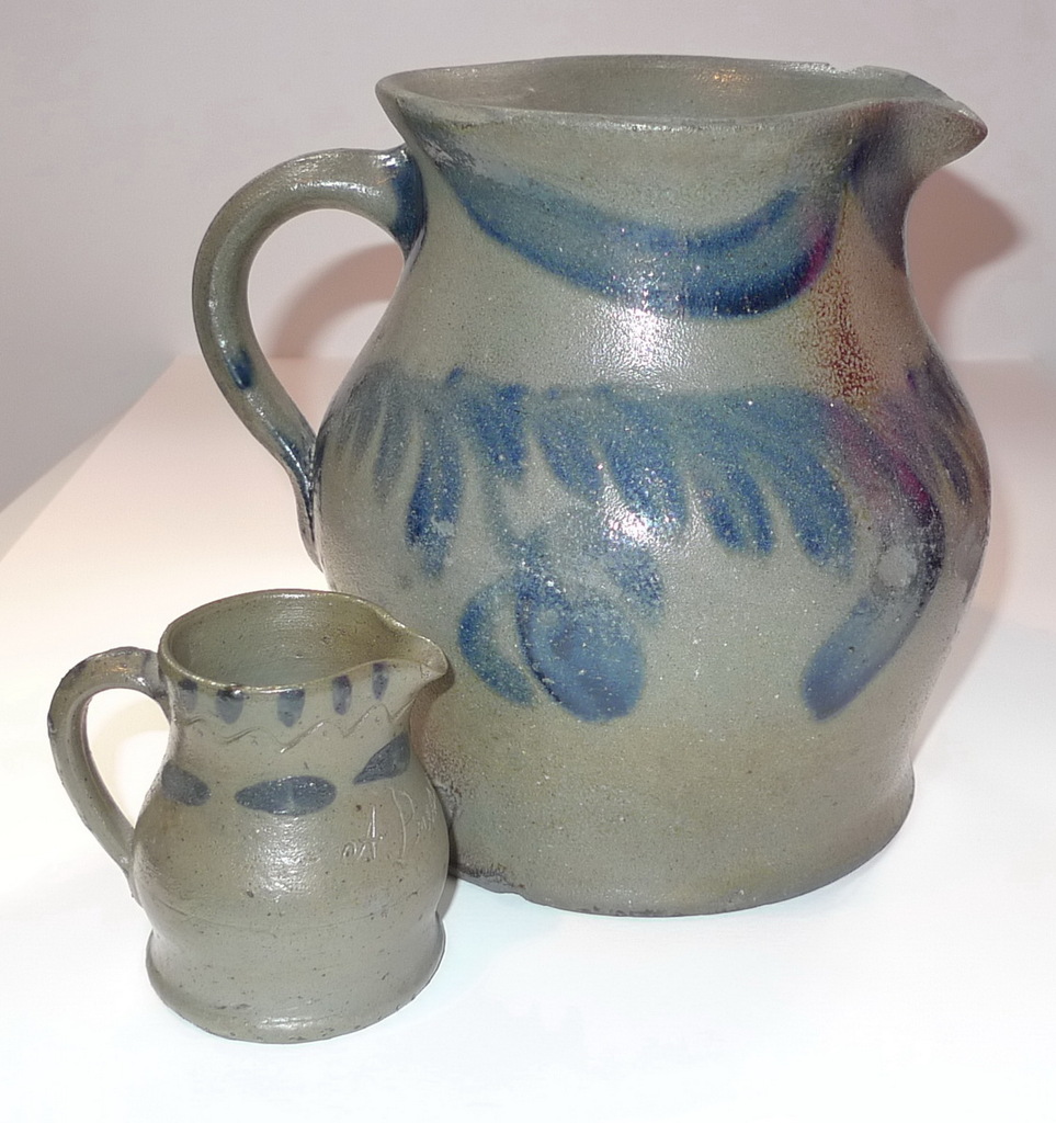 A Present pitcher beside a large decorated pitcher. ai6.