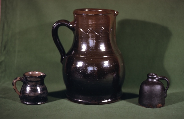 Three pieces of pottery seen in the group of ten on the grass. The small pitcher is basically covered with cobalt and dated on the bottom 1906. Burbage34.